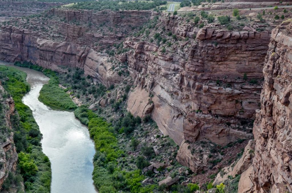 Kronkelende rivier stroomt door een diepe canyon met steile rode rotswanden in Colorado