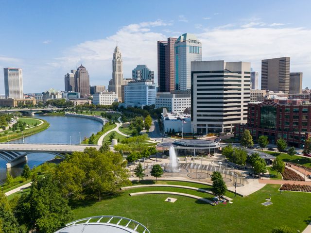 Wolkenkrabbers van Columbus in Ohio met de LeVeque Tower, een rivier met bruggen en een fontein in een groen park