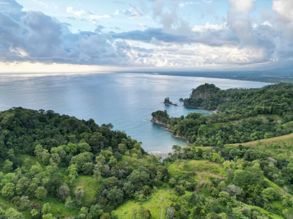 Luchtfoto van een groene, beboste kustlijn met kleine baaien en helderblauw water in Costa Rica