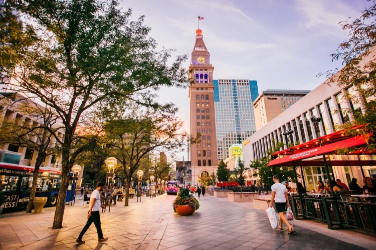 Winkelboulevard 16th Street Mall in Denver in Colorado met wandelaars, terrasjes en de historische Daniels and Fisher klokkentoren