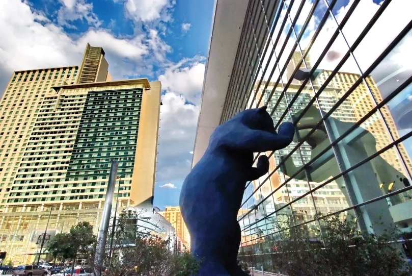 Groot blauw beeld van een beer dat door de ramen van het congrescentrum in Denver in Colorado gluurt tussen wolkenkrabbers