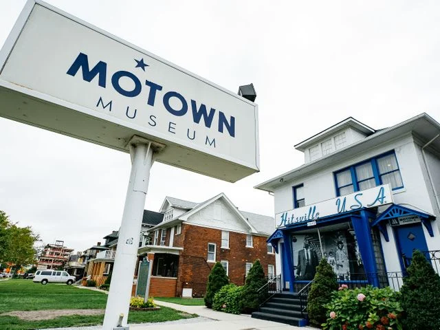 Wit bord met het opschrift Motown Museum naast het blauwwitte pand van Hitsville USA in Detroit