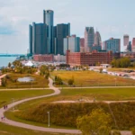 Groen wandelpark met een vijver langs de oever van de Detroit River met de wolkenkrabbers van Detroit op de achtergrond