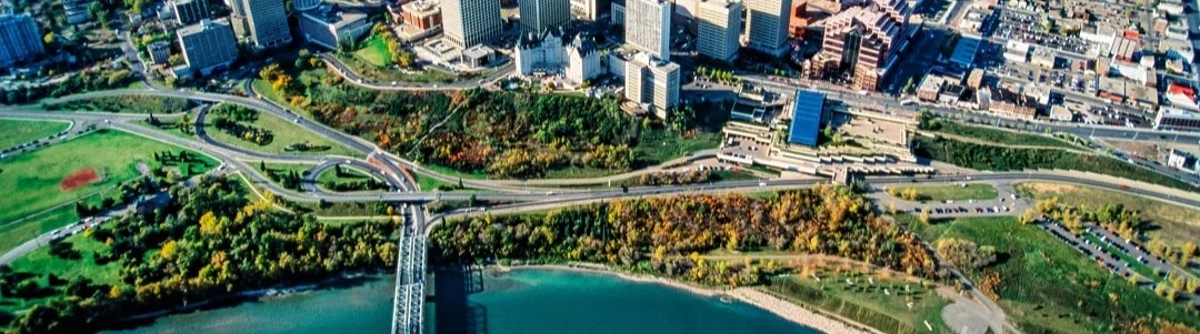 Luchtfoto van Edmonton toont een brug over de rivier, groene parken en de skyline op de achtergrond