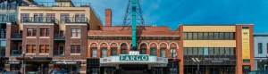 Groen en rood neonbord met de tekst Fargo hangt boven de ingang van een historisch bioscooptheater aan de hoofdstraat