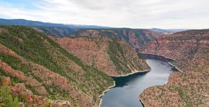 Panoramisch uitzicht over een diepe rode rotskloof met een blauw meer erdoorheen bij Flaming Gorge in Utah