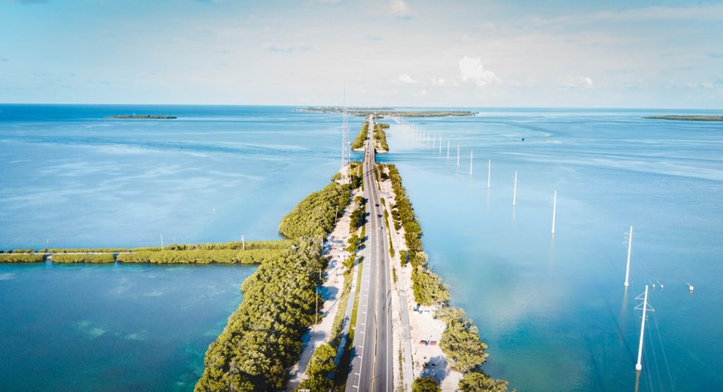 Luchtfoto van een lange brug die over helderblauw water tussen twee eilanden loopt in de Florida Keys