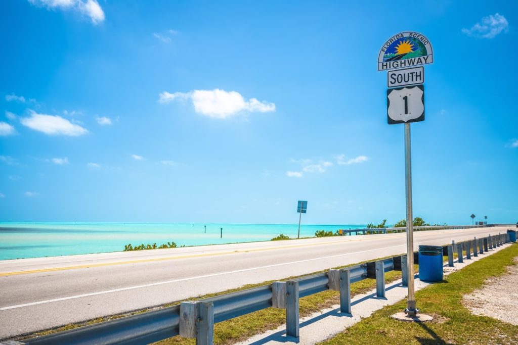 Bord van Highway 1 South naast de weg met uitzicht op turquoise water en een vrijwel lege snelweg