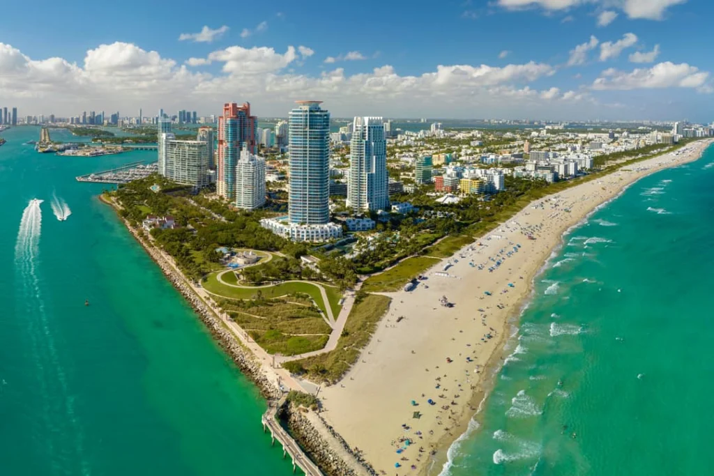Luchtfoto van Miami Beach in Florida met wolkenkrabbers, een zandstrand vol mensen en turquoise oceaanwater