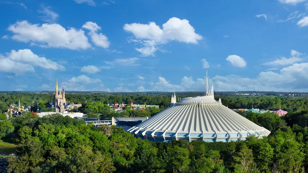 Luchtfoto van het witte gebouw van attractie Space Mountain tussen de bomen van Magic Kingdom met kastelen op de achtergrond