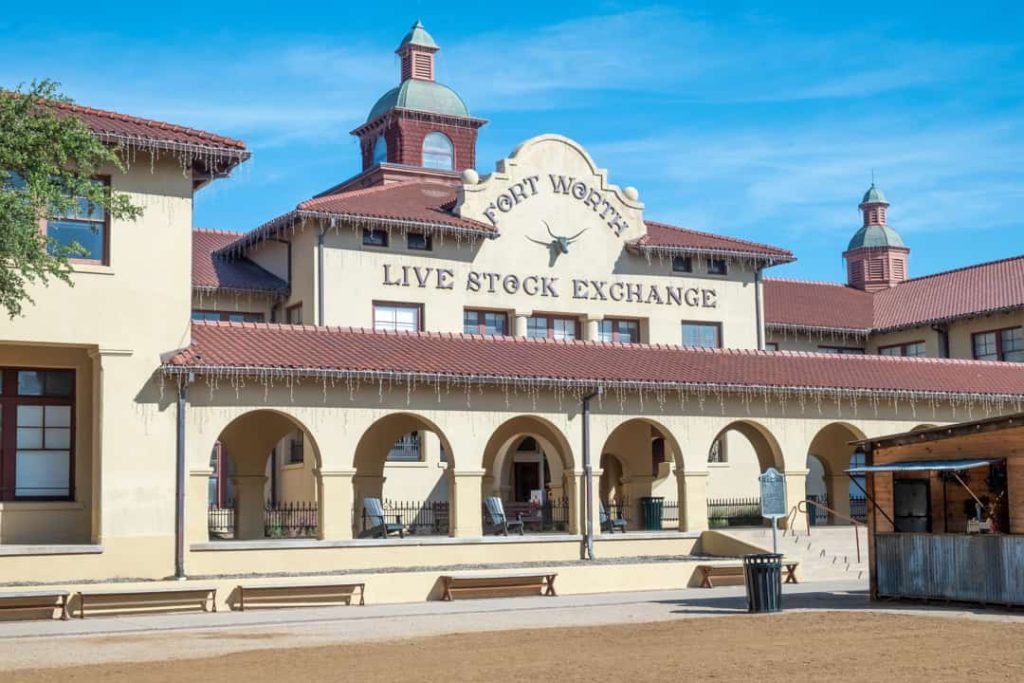 Historisch gebouw met rode dakpannen en koepeltjes met de tekst fort worth live stock exchange op de gevel