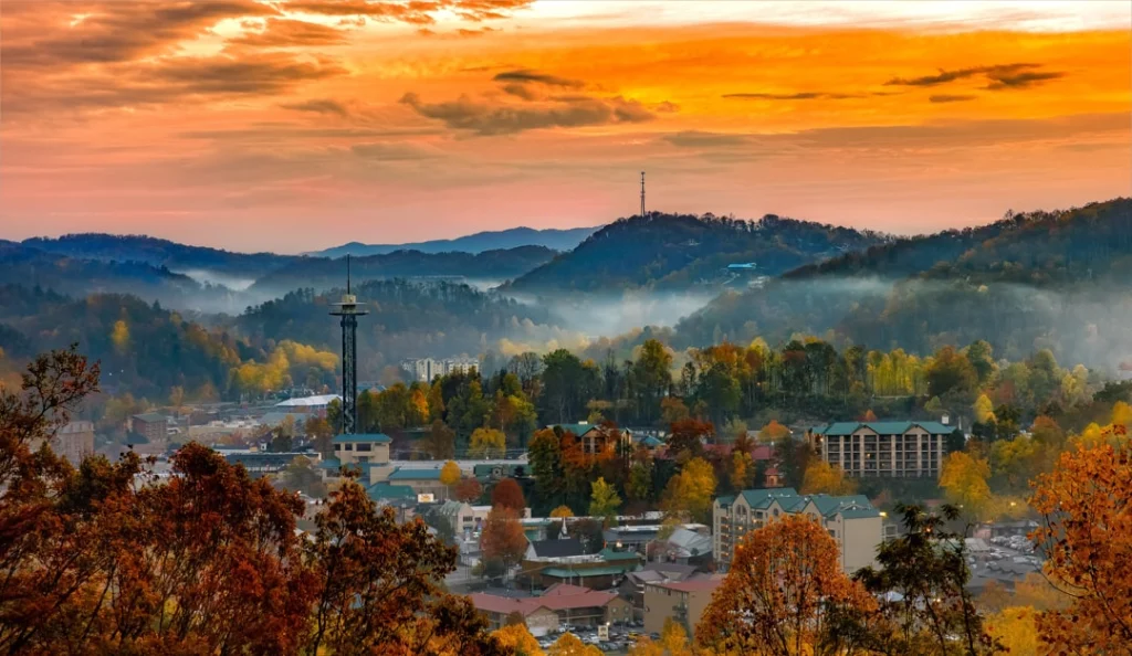 Uitzicht over het plaatsje Gatlinburg tussen de bergen van de Smoky Mountains, met een oranje avondlucht