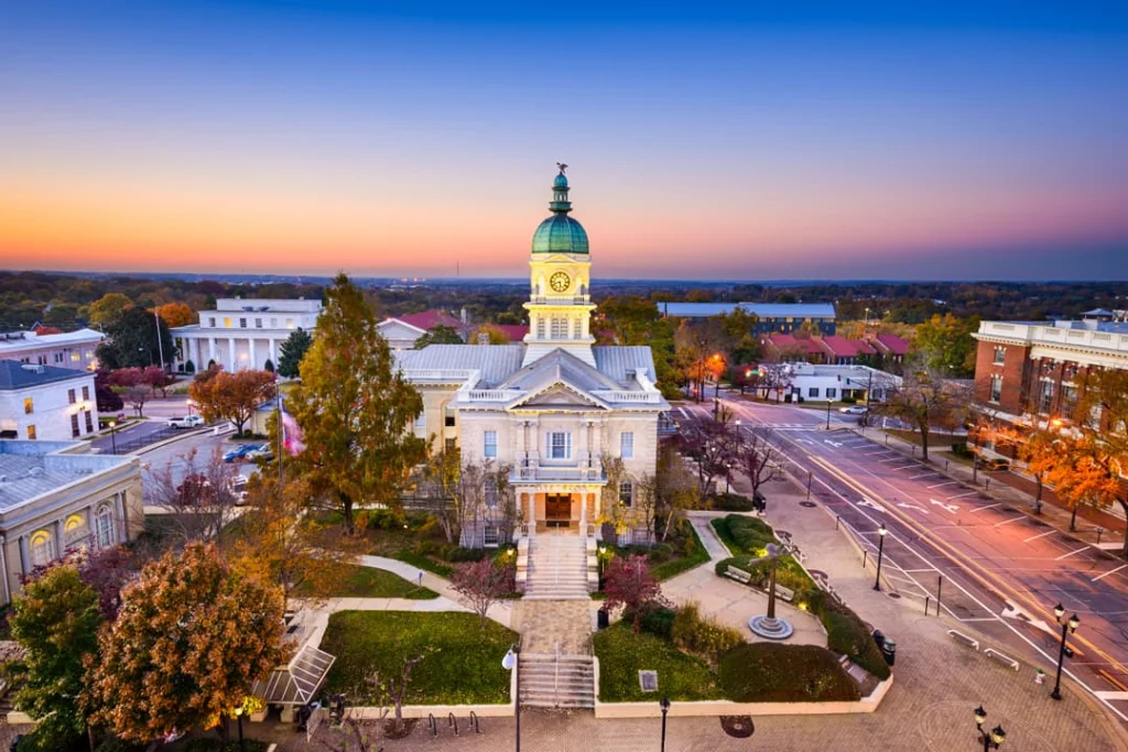 Luchtfoto van een historisch wit gerechtsgebouw met groene koepel in een Amerikaans stadscentrum in Georgia tijdens zonsondergang