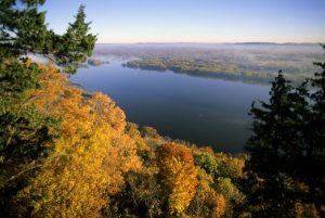 Uitzicht vanaf een heuvel met herfstbladeren over de brede Mississippi rivier onder een ochtendmist in Minnesota