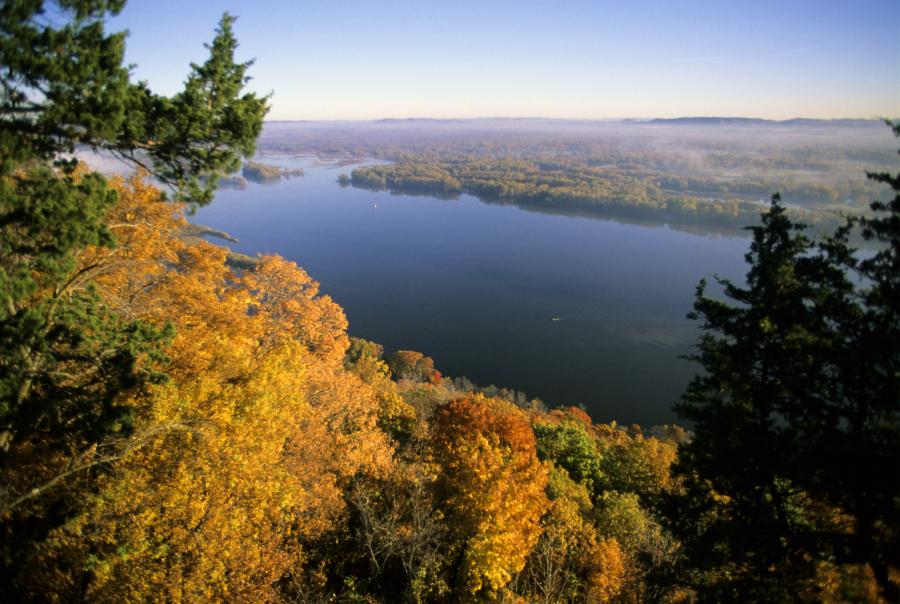 Uitzicht vanaf een heuvel met herfstbladeren over de brede Mississippi rivier onder een ochtendmist in Minnesota