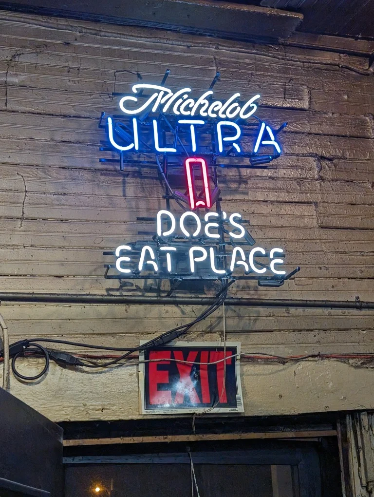 Neonreclame met de tekst Michelob Ultra en Doe's Eat Place aan de gevel van een houten gebouw in Greenville, Mississippi