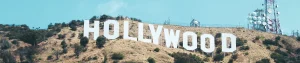Grote witte letters van het Hollywood bord staan op een droge heuvel met antennemasten tegen een strakblauwe hemel