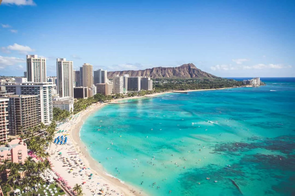 Luchtfoto van het turquoise water en witte strand van Waikiki Beach met hoogbouw en de krater Diamond Head