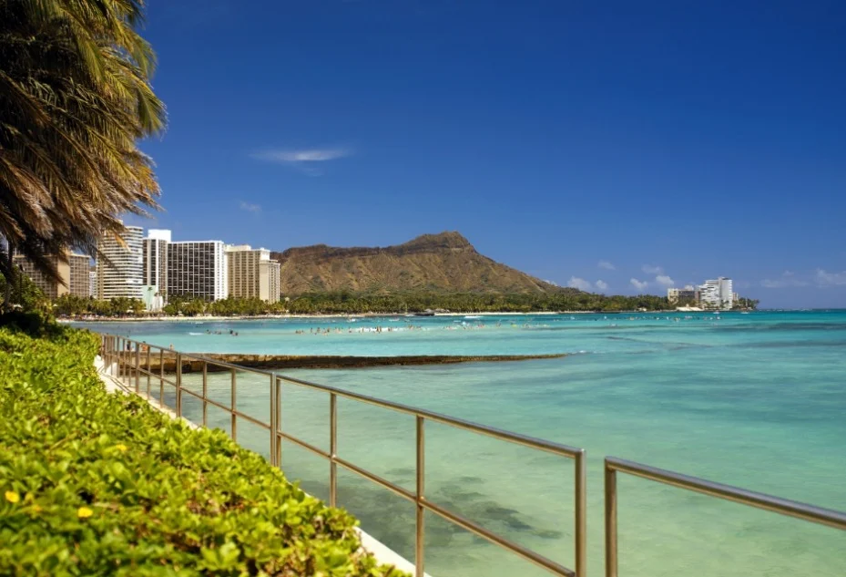 Turkoois water van Waikiki Beach met op de achtergrond hotels en de vulkaankrater Diamond Head in Honolulu