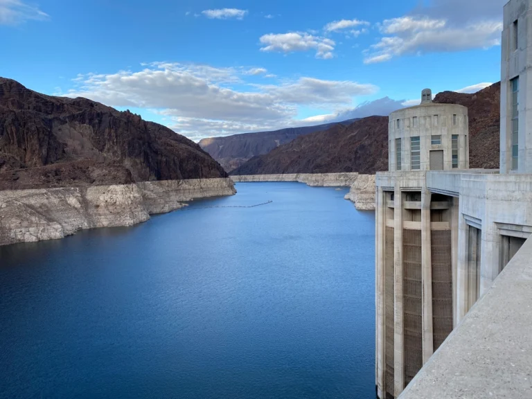 Blik vanaf de Hoover Dam over het blauwe water van Lake Mead, omringd door rotsachtige canyonwanden en de kenmerkende inlaattorens