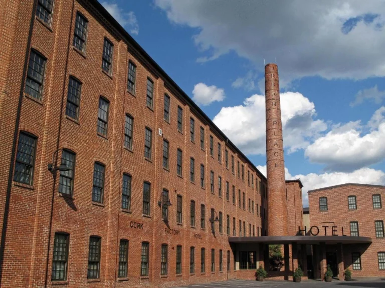 Rood bakstenen voormalige kurkfabriek met een hoge industriële schoorsteen, nu ingericht als het Cork Factory Hotel in Lancaster