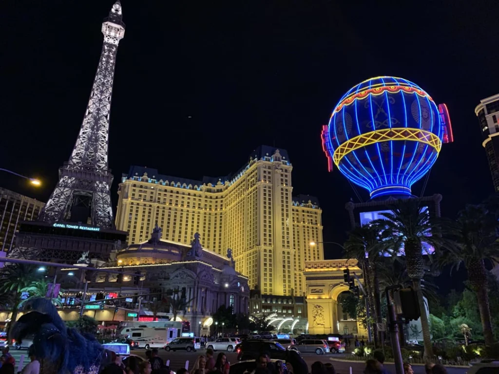 Verlichte Eiffeltoren replica en een gekleurde luchtballon versieren de gevel van het Paris hotel aan de Las Vegas Strip in de avond