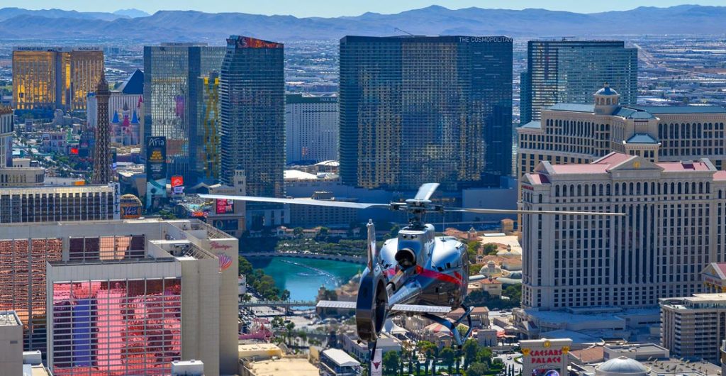 Een helikopter vliegt boven de hotels van de Strip met het Cosmopolitan en Bellagio zichtbaar in Las Vegas