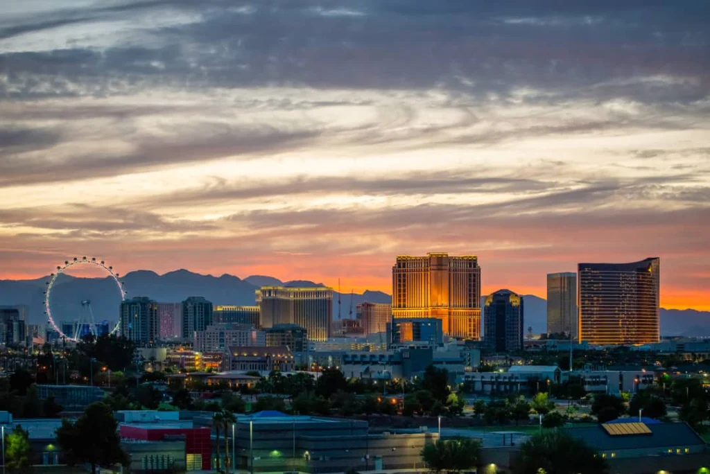 Silhouet van hotels en het reuzenrad van Las Vegas tegen een oranje en paarse lucht bij zonsondergang