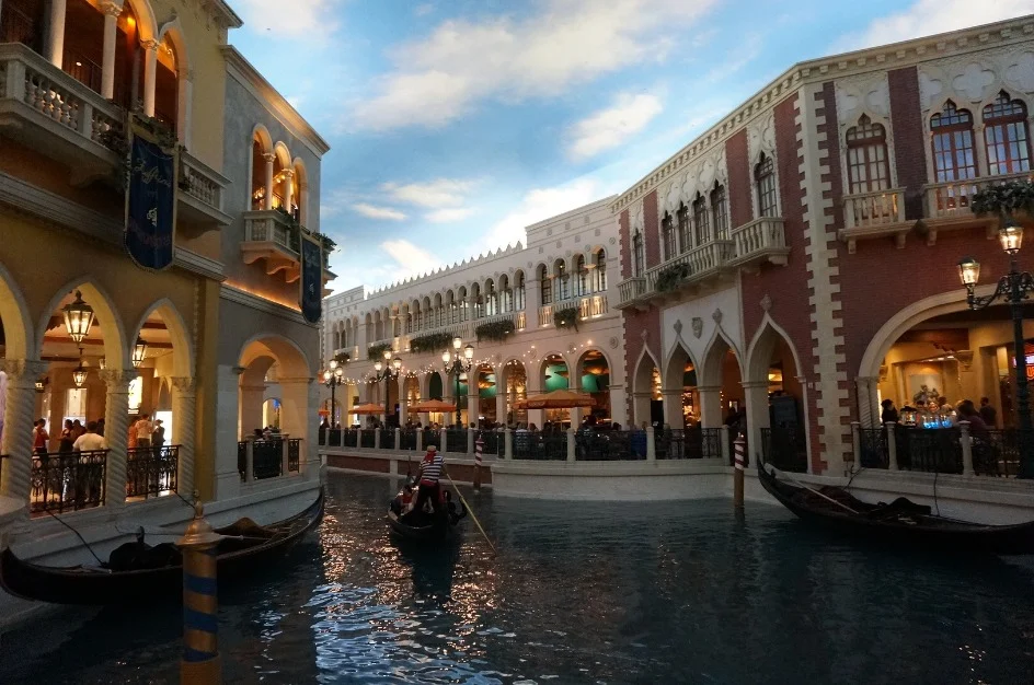 Gondelier vaart toeristen rond op het nagebootste kanaal binnen hotel The Venetian in Las Vegas tussen Italiaans ogende gevels