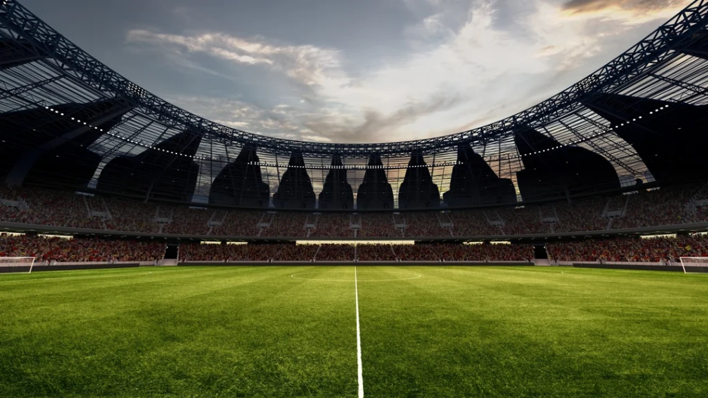 Panoramisch zicht op een leeg groen voetbalveld omringd door tribunes onder een bewolkte avondlucht