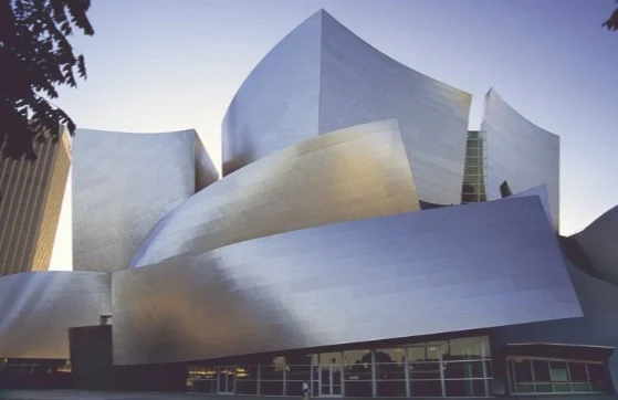 Golvende gepolijste stalen gevel van de Walt Disney Concert Hall glanst in het avondlicht in Los Angeles