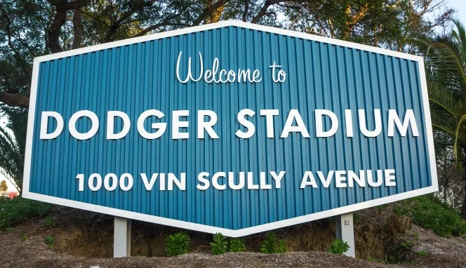 Blauw zeshoekig bord met de tekst Welcome to Dodger Stadium en het adres 1000 Vin Scully Avenue