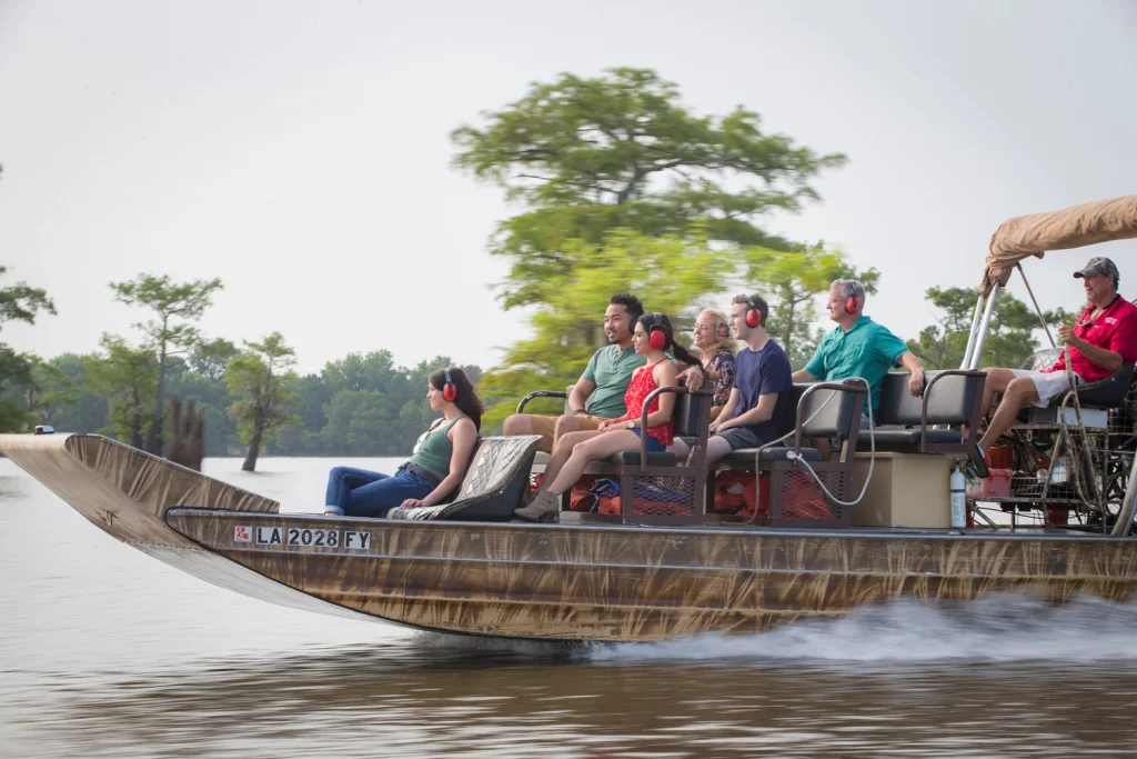 Een groep passagiers met gehoorbescherming vaart op een airboat door het moerasgebied nabij Henderson in Louisiana