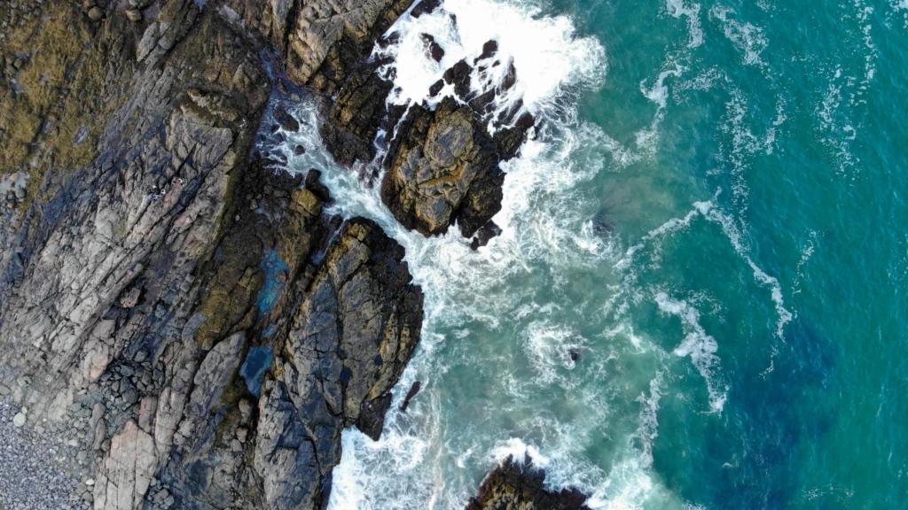 Luchtfoto van een kustplaats in Maine met een drukke jachthaven vol boten en beboste bergen op de achtergrond