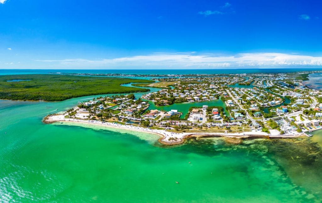 Luchtfoto van een eilandenreeks met woningen aan het water omringd door helder turquoise en groen zeewater