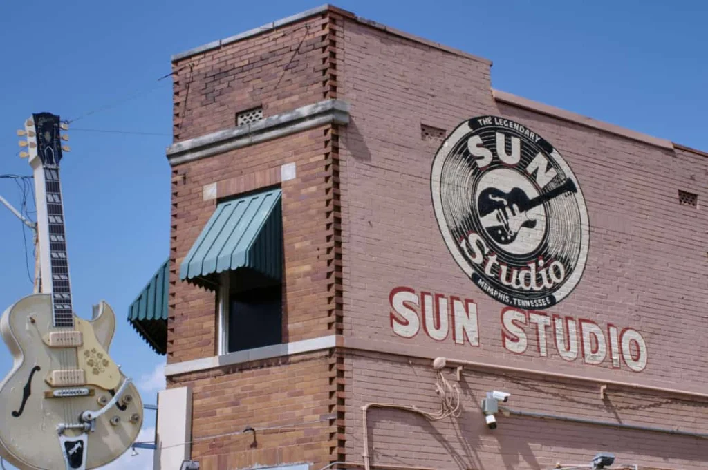 De bakstenen gevel van het beroemde Sun Studio met een grote gitaar ernaast in Memphis