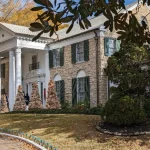 Voorzijde van het herenhuis Graceland in Memphis met witte zuilen, groene luiken en kerstversiering bij de ingang