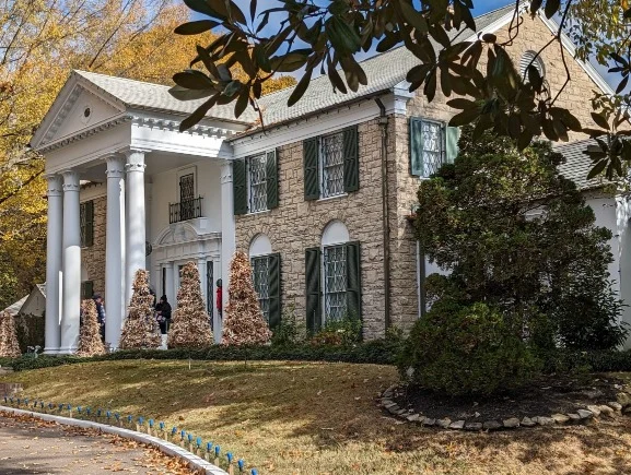 Voorzijde van het herenhuis Graceland in Memphis met witte zuilen, groene luiken en kerstversiering bij de ingang