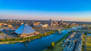 Luchtopname van de glazen piramide van Memphis naast de rivier met de skyline van de stad op de achtergrond onder een strakblauwe lucht