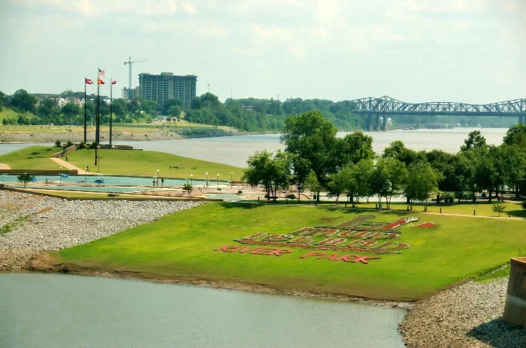 Groen park met bloemenperk in bloembedletters aan de oever van de Mississippi in Memphis, met een brug en skyline op de achtergrond