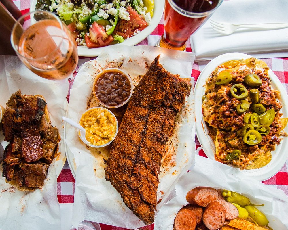 Tafel met gerookte ribben, worstjes, nacho's en salade op een roodwit geblokt kleed in het Rendezvous restaurant in Memphis