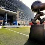 Een groot bronzen standbeeld van Snoopy staat op het plein voor het MetLife Stadium onder een heldere lucht
