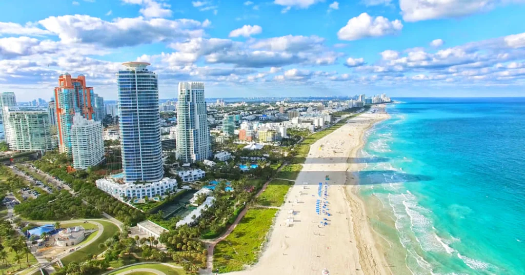 Luchtfoto van Miami Beach met een rij hoge appartementengebouwen langs een smalle landtong tussen zee en baai