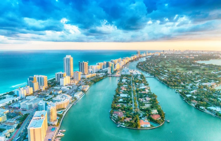 Luchtfoto van Miami met wolkenkrabbers aan de kust, groene eilanden in de baai en een bewolkte lucht