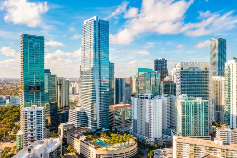 Luchtfoto van de skyline van Miami met hoge glazen wolkenkrabbers en appartementengebouwen onder een blauwe lucht met wolken