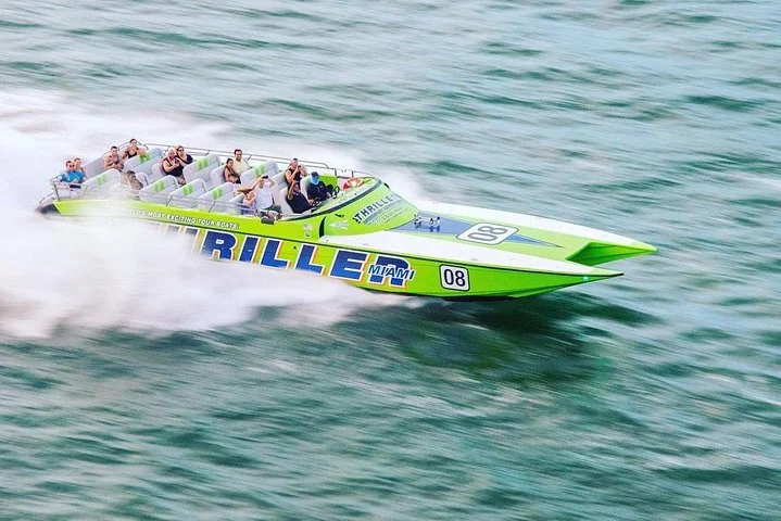 Een groene en witte speedboot met de naam Thriller Miami snijdt met hoge snelheid door het water terwijl passagiers vastgegespt zitten