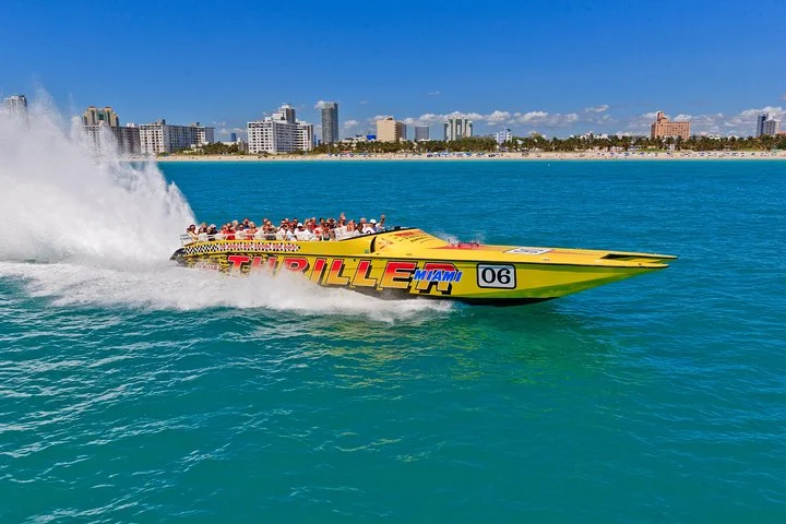 Gele speedboot met toeristen aan boord raast door het water met de skyline van Miami en het strand op de achtergrond