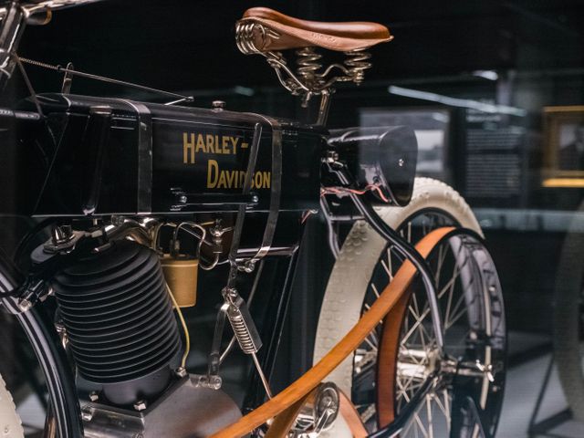 Close-up van een antieke zwarte Harley-Davidson motorfiets met leren zadel en houten wielen in het Harley-Davidson Museum in Milwaukee