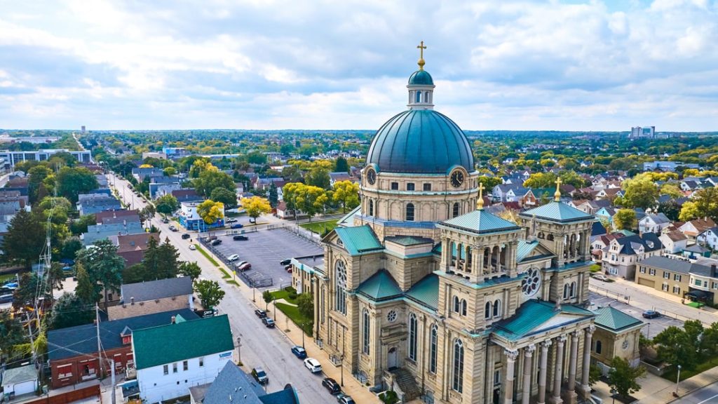 Luchtfoto van de koepelbasiliek van Sint-Josaphat in Milwaukee met de omliggende woonwijk en bomen op de achtergrond