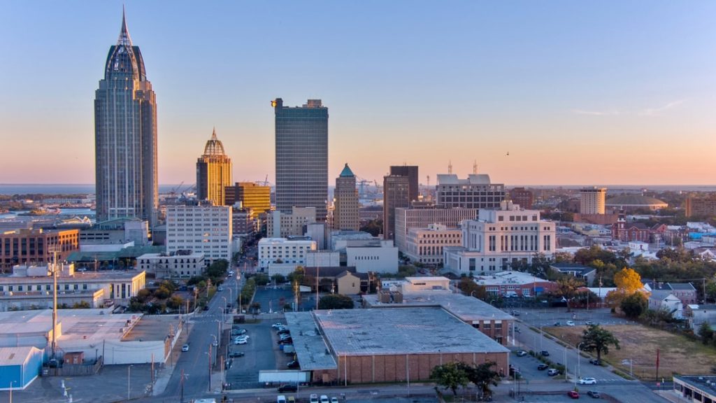 Wolkenkrabbers van downtown Mobile met de spitse RSA Battle House Tower op de voorgrond bij zonsopkomst